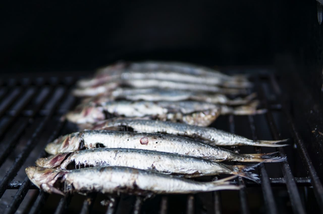 Photo de plusieurs sardines sur une grille de four.