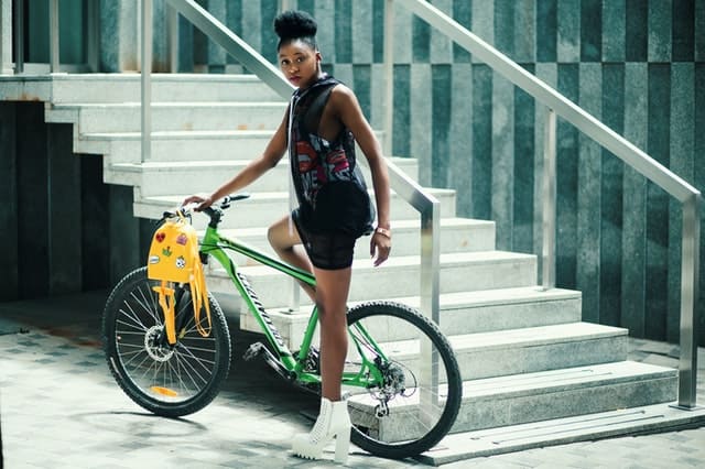 Femme qui fait du vélo à côté d'un escalier.